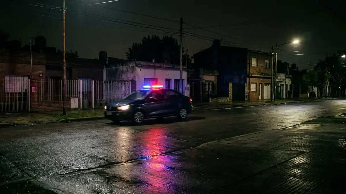 Patrullero genérico recorriendo de noche una calle residencial del conurbano.